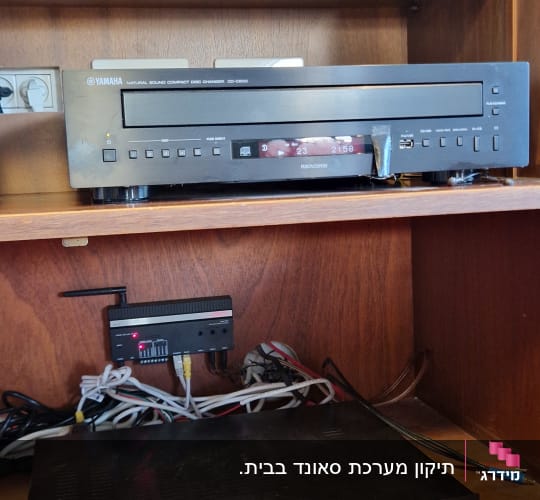 מערכת שמע עם כבלים ומכשירים טכניים בארון עץ